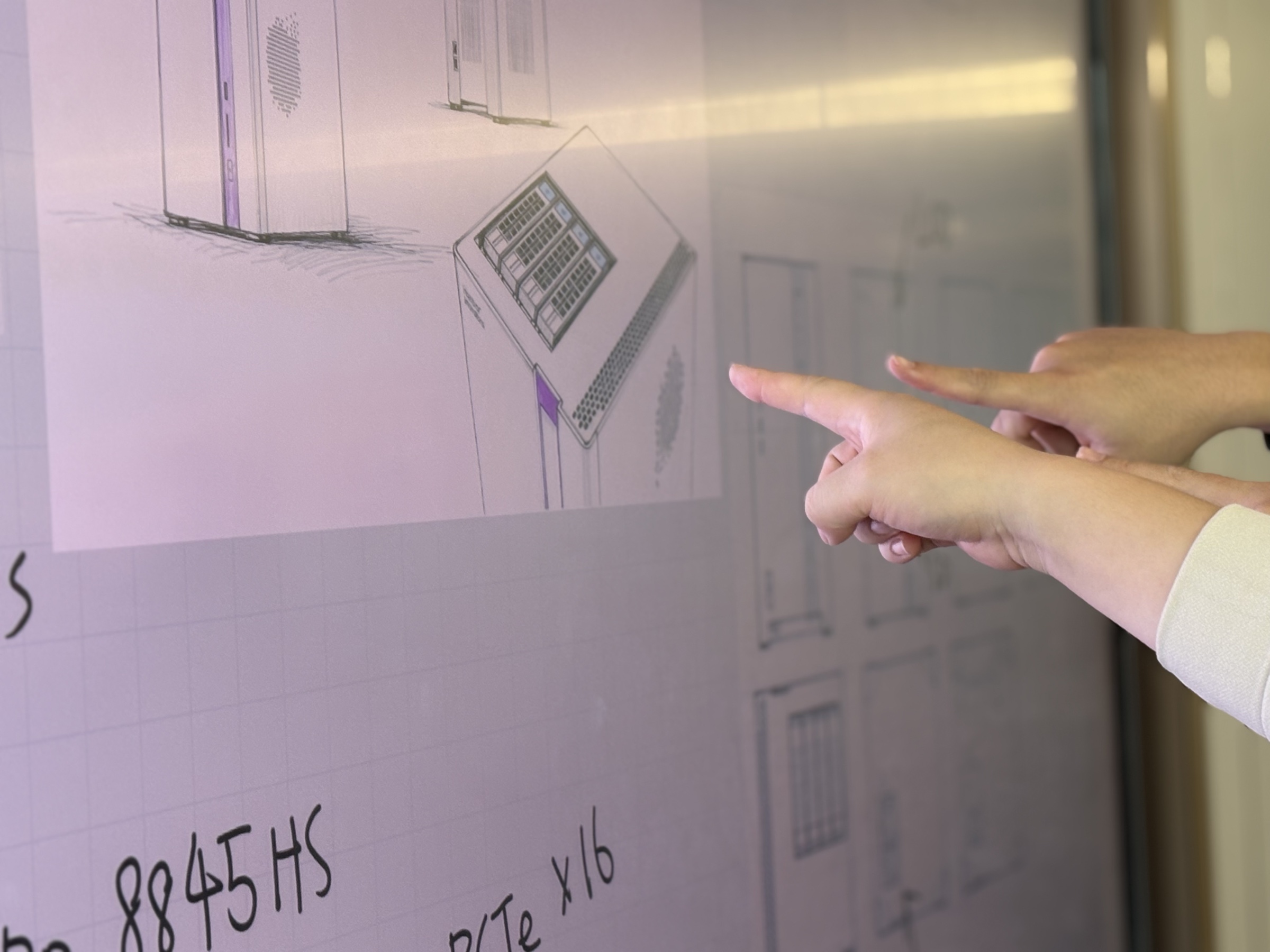 Team members reviewing a Nexus enclosure concept on a display