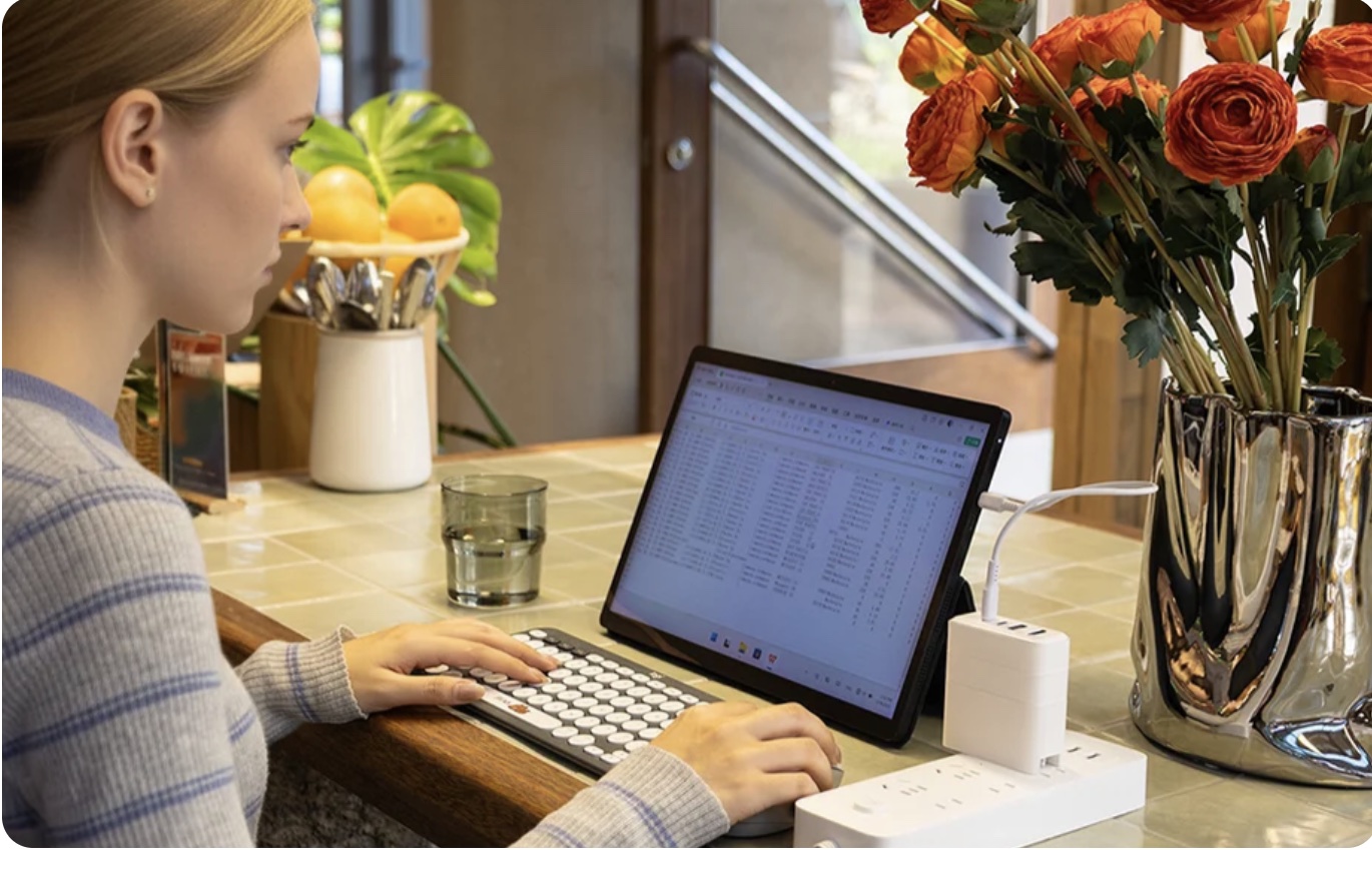 A person working at a cafe with Bricbloc charging a tablet computer